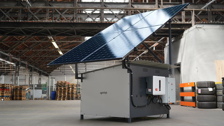 upVolt Power Tower (40 kWh): freistehender Speicher mit aufgesetzten Solarmodulen und Wechselrichter, in einer Industriehalle.